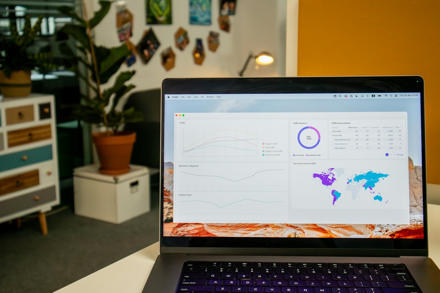 Laptop menampilkan dasbor analitik digital di atas meja putih.